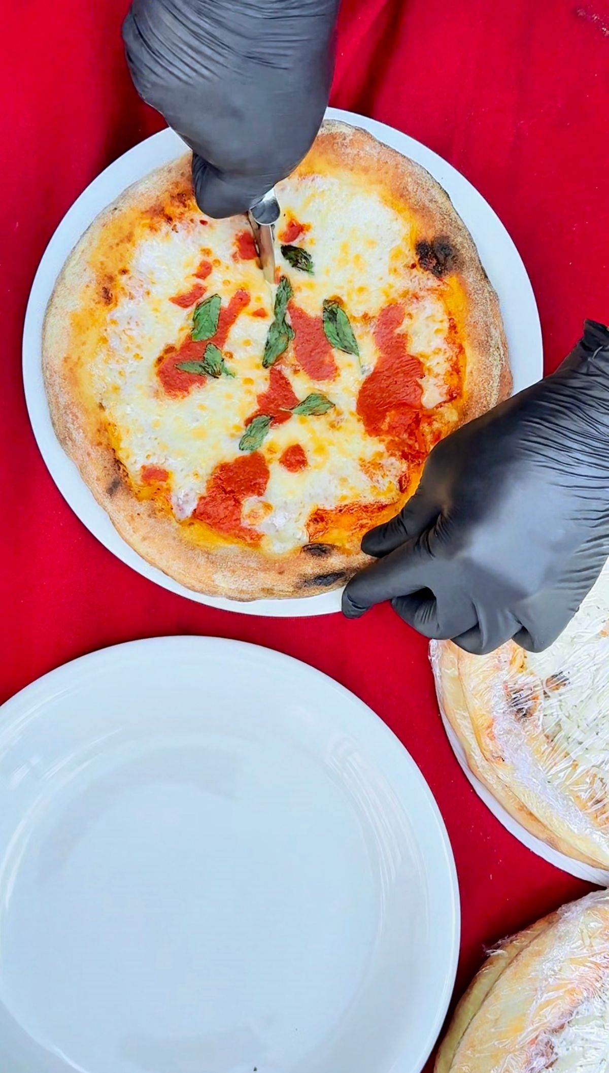 Pizza sendo fatiada para a degustação da inauguração