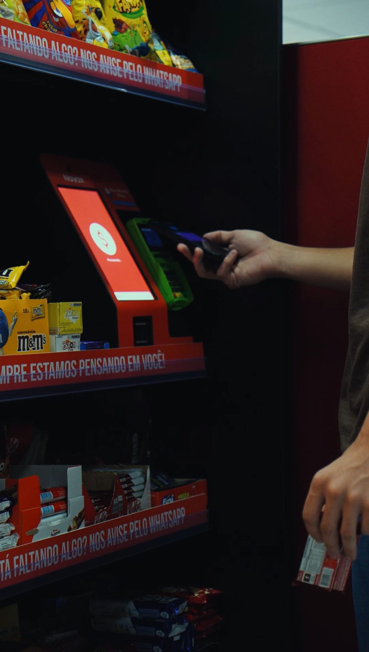Cliente aproxima o cartão da maquininha do totem de autoatendimento